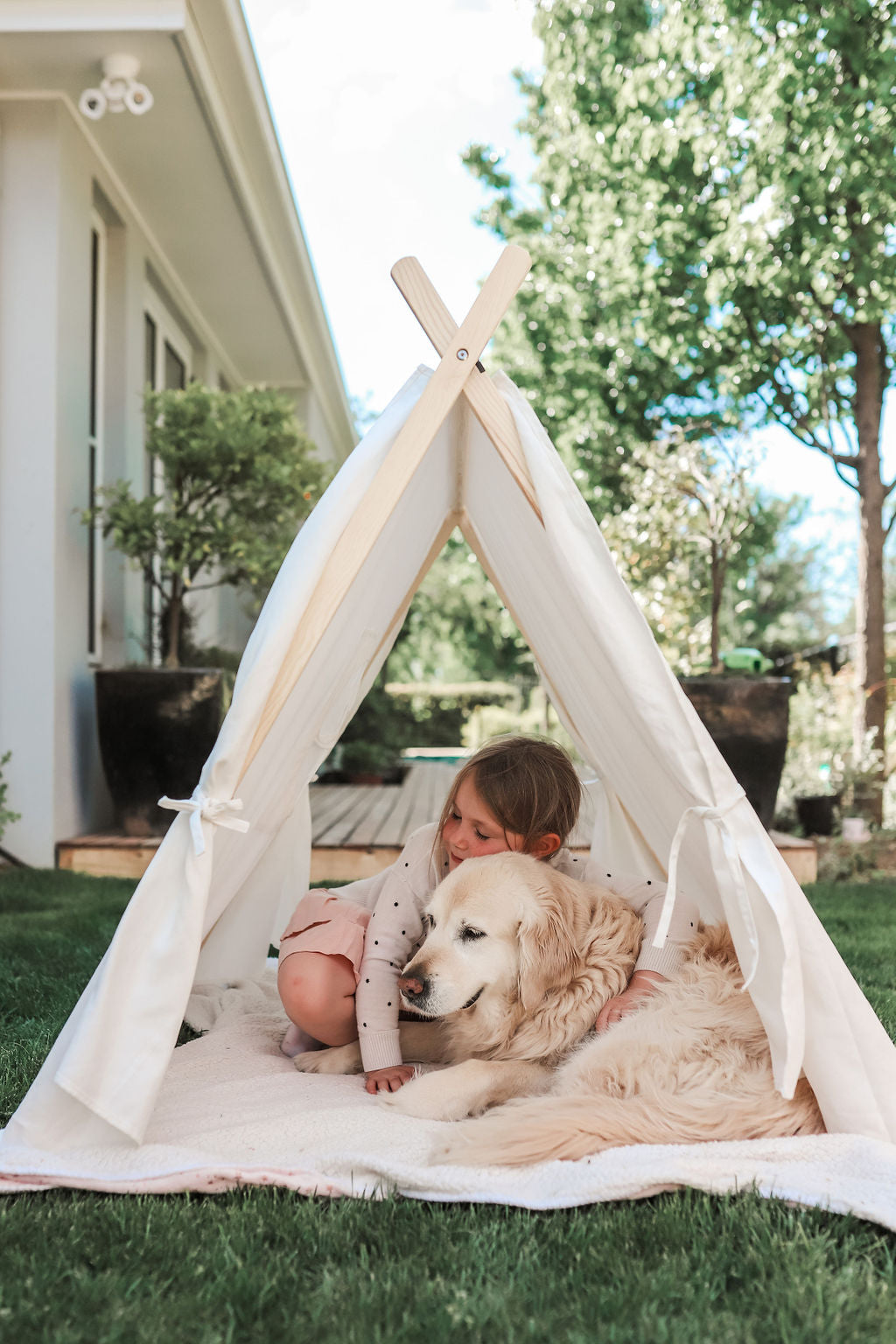 Image of child and golden retriever sitting inside Petite Maison Play Safari Tent cubby