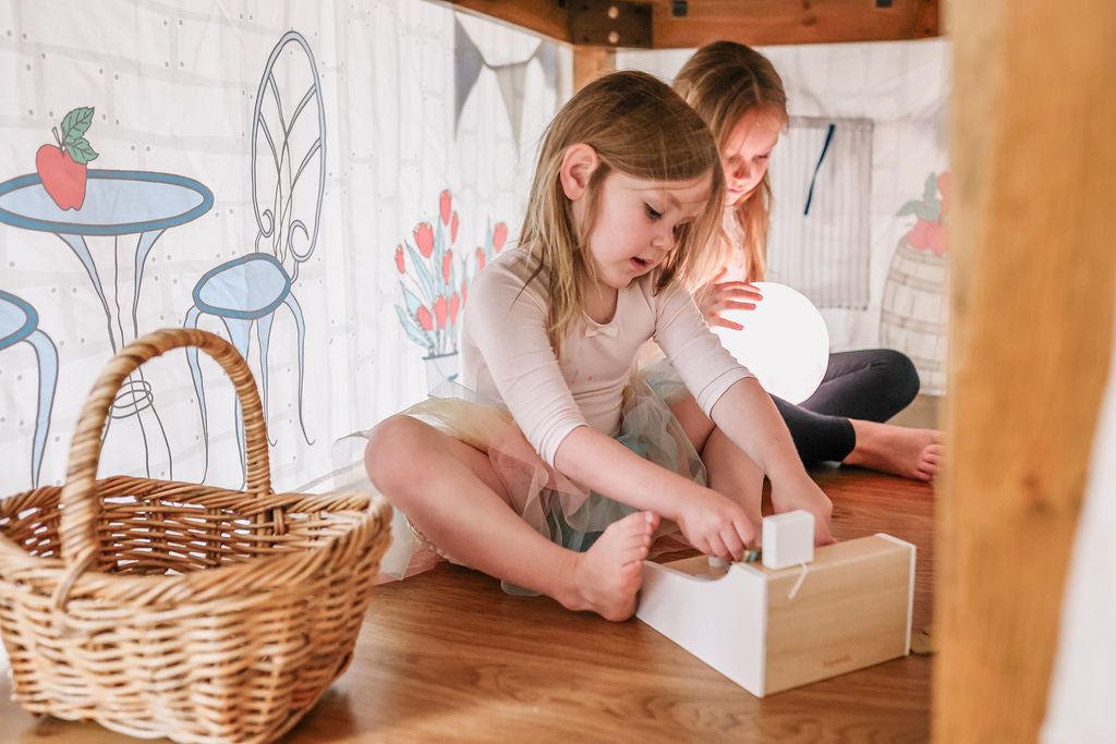 Image of young Children playing below the Petite Maison Play Petite Shop Table Tent. 