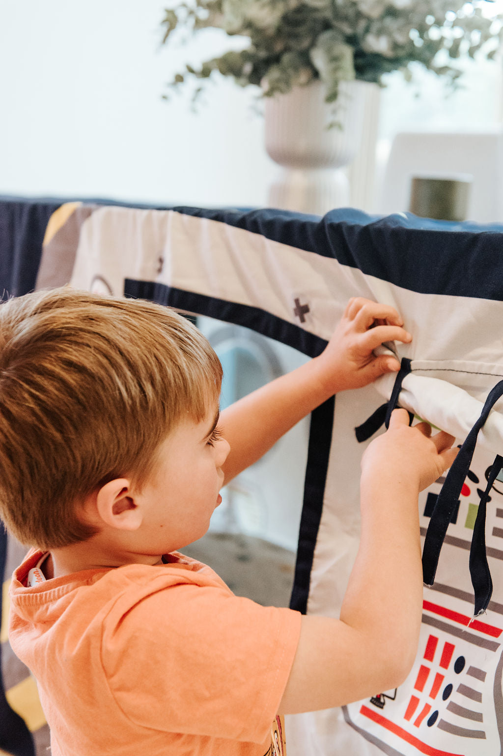 Child playing outside Petite Maison Play Space station indoor cubby house. 